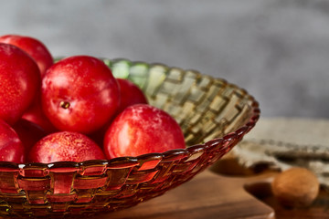Red plums in a glass fruit plate