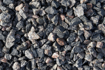 Medium-sized granite crushed stone. The stone is gray with a splash of pink and red. Material for the manufacture of building structures and roads.
