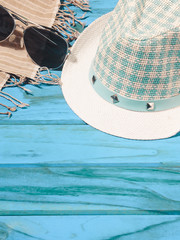 Fototapeta na wymiar Slippers and a hat and sunglasses on a blue wooden floor Summer concept