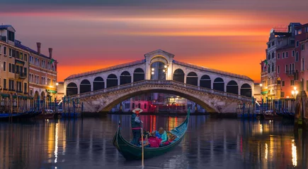 Wallpaper murals Rialto Bridge Gondolier carries tourists on gondola Green Canal near Rialto Bridge at sunset - Venice, Italy