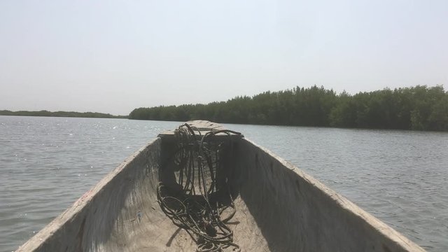 Traditionelles Einbaum Fischerboot f&auml;hrt durch Mangoven in der Casamance, Senegal