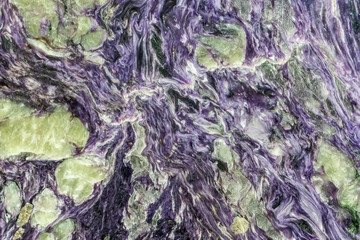 Purple swirl. Abstract natural crystal pattern. Charoite silicate mineral close-up.