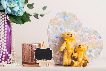 A couple of textile bears, a vase of flowers, a candlestick and other nice things on the dresser in the bedroom