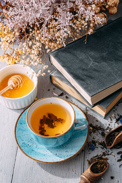 tea and a book in the spring sunshine. near honey and flowers
