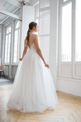 Brown-haired girl in a beautiful white wedding dress. A woman bride is waiting for the groom before the wedding