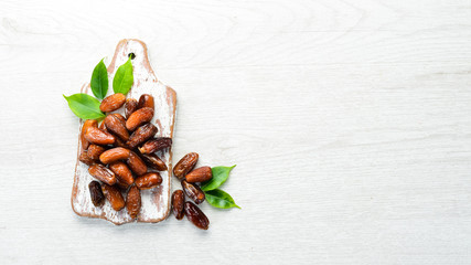 Dried sweet dates on white wooden background.