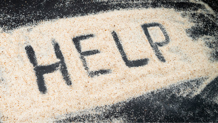 HELP text written on white sand