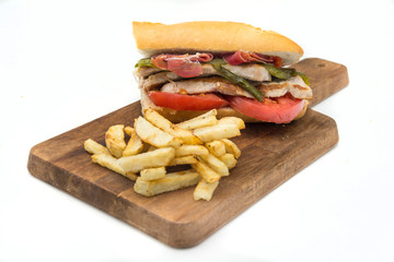 Sandwich Serranito typical in Andalusia with ham, gren pepper and grilled pork loin