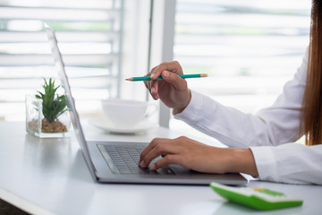 Businesswoman or accountant. Work in a creative and modern room.The laptop is on the table.  Rest...