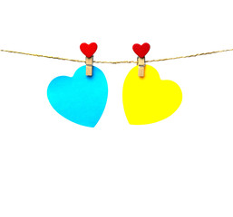 two blue and yellow hearts hanging on a rope attached with trailers