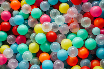 Colorful array of plastic balls in a ball pit.