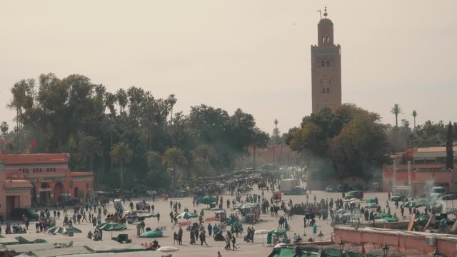 Crowd of people in Jamaa El Fna square and El Koutoubia Mosque - Marrakech, Morocco