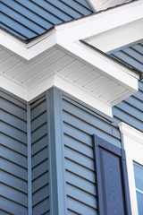 Colonial white   soffit providing ventilation to the attic, with pacific blue vinyl horizontal siding, blue shutter at a luxury American single family home neighborhood USA