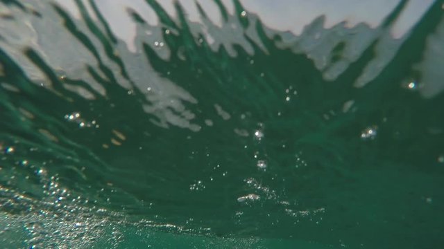 Outdoor GoPro dangerous footage video of wave hitting camera on sand beach.