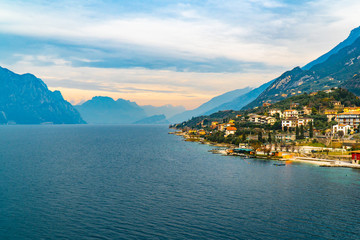 Obraz premium Lake Garda Italy in cold foggy day in winter holidays with city historical view, lake and mountain and cable car 