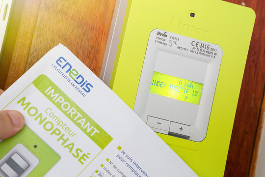 Hand holding the opening contract for a linky box ERDF (Electricity Network Distribution France) in the entry of Building