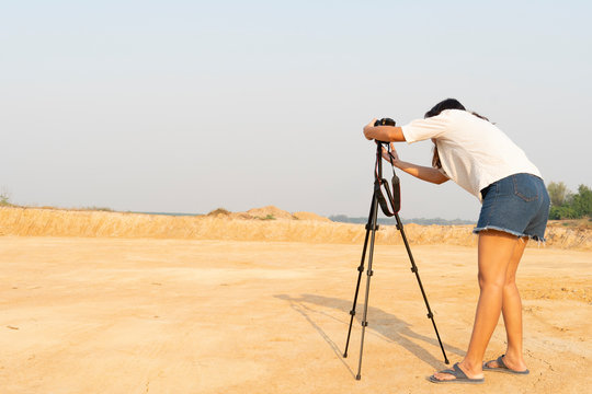 photographer at work take photos of an outdoor location surrounded by soil.