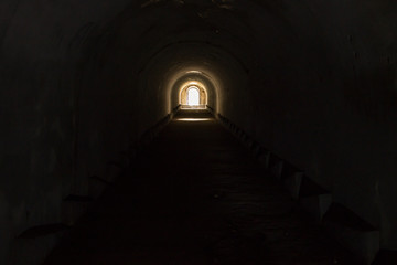 A lighted door leading to freedom from a gloomy dark underground passage at Pospelov Fort in...