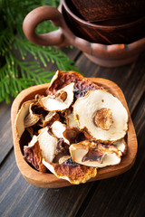 Dried mushrooms ceps boletus edulis. Ingredient for vegetarian food. In a wooden bowl on a dark background