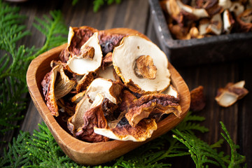 dried forest mushrooms ceps and boletus scattered on a dark wooden table. Rustic style