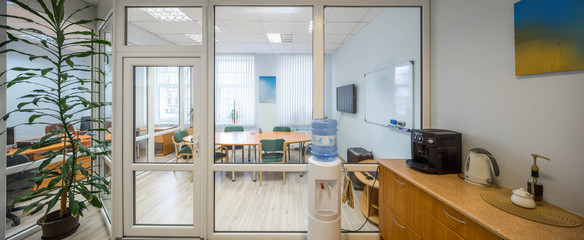 Modern interior of kitchen in office. Glass door and wall. Meeting room. Corporate culture.