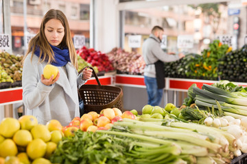 Female shopper picks apples at grocery store