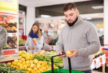 Fototapeta premium Male customer buying lemon at supermarket