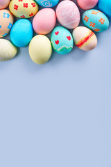 Fototapeta na wymiar Colorful Easter eggs dyed by colored water with beautiful pattern on a pale blue background, design concept of holiday activity, top view, copy space.
