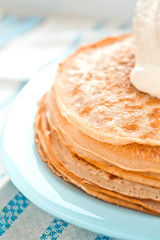pancakes with sour cream are stacked on top of each other in close-up