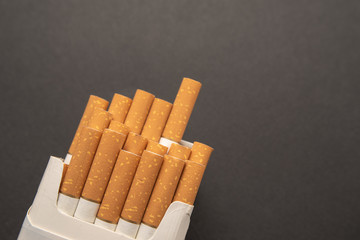 Cigarettes in pack. Yellow filter. Harm to health. Bad habit.