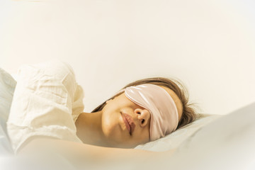 Fototapeta premium Woman sleeping on bed with eye mask on.