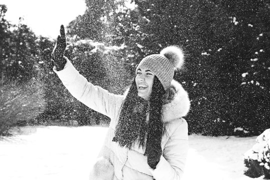 a girl playing snowballs in winter in parck