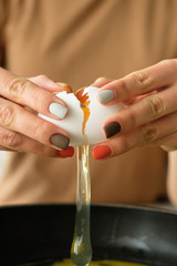Female hands break an egg, cooking egg dishes