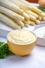 White hollandaise sauce in bowl, traditional sauce for dishes with cooked white asparagus
