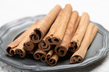 Winter food ingredient, dried aromatic cinnamon sticks on tin plate