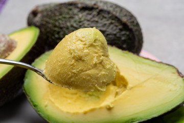 Eating of fresh ripe green organic hass avocado fruit with spoon