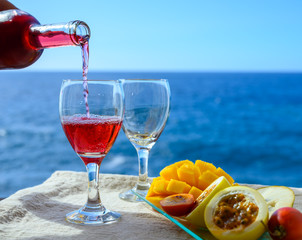 Two glasses with rose wine served outdoor with exotic fruits on tropical island La Palma, Canary...