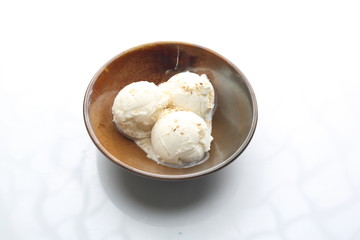 Three scoops of ice cream in a bowl. Appetizing dessert isolated on white.