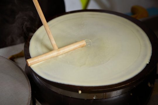 Making crepe with wooden stick 