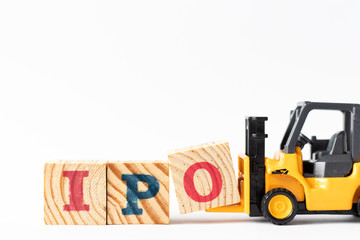 Toy forklift hold wood letter block O to complete word  IPO (Abbreviation of Initial Public...