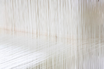 Closed up of loom with white thread background