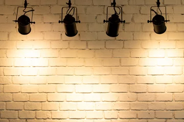 Rolgordijnen Hanging spotlight illuminate at brick wall background with copy space © bankrx