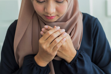 Close-up Muslim women dressed in black hijab, praying and praying to Allah Religious rituals for...