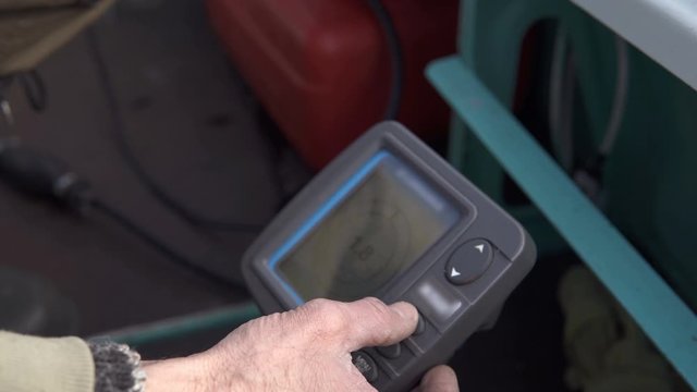 Fisherman adjusts sonar before leaving on a fishing trip. The concept of the instrument to search for fish.