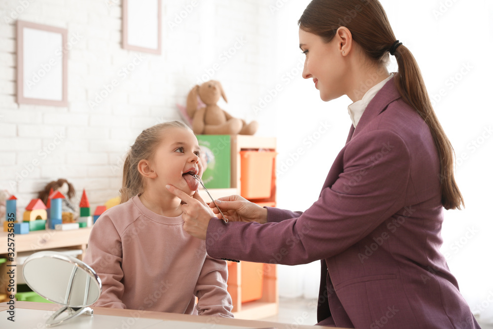 Canvas Prints Speech therapist using logopedic probe on session with little girl in office