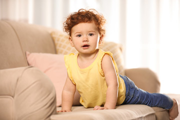 Portrait of cute little child on sofa at home