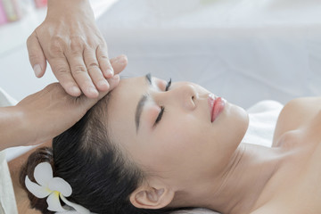 Beautiful Asian woman relax with a facial massage at the spa, all by professional massage. Spa concept for relaxation and stress therapy
