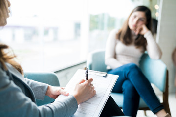 Therapist Making Notes During Session With Patient