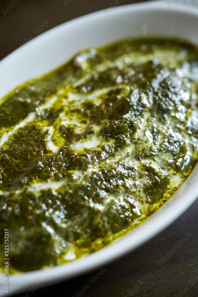 Wall mural Spinach curry in white dish