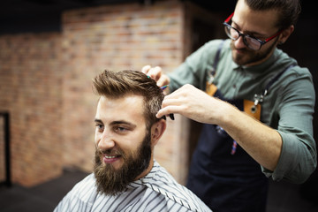 Client during beard and moustache grooming in barber shop